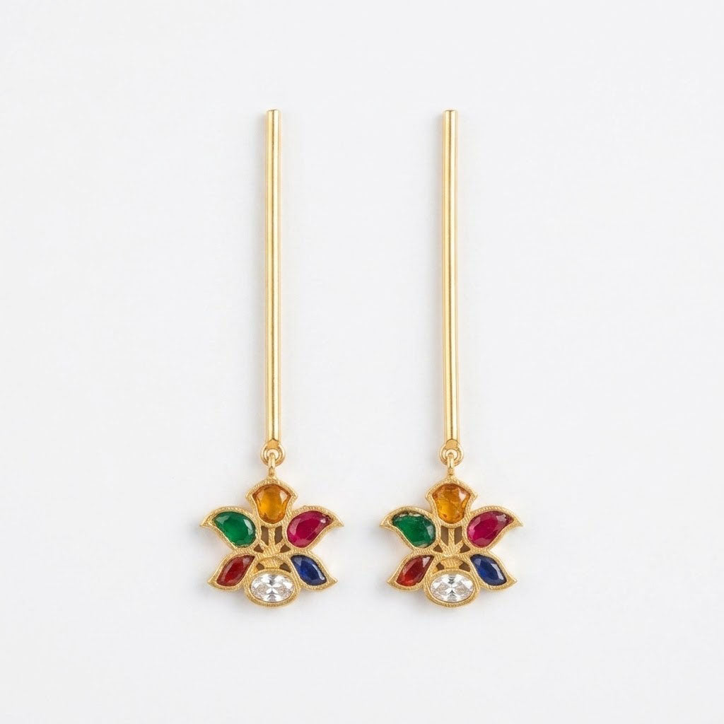 A pair of gold dangle earrings with long straight posts and a floral drop charm featuring multicolored enamel-like details and a clear central stone, shown on a plain white background.